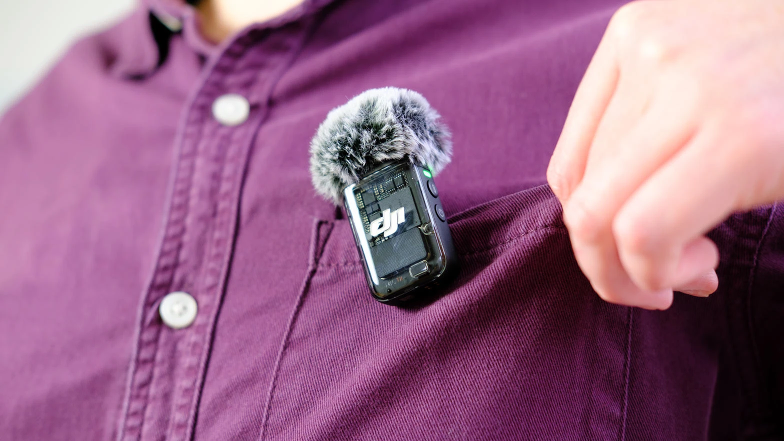 Передатчик DJI Mic с ветрозащитой закреплён на рубашке